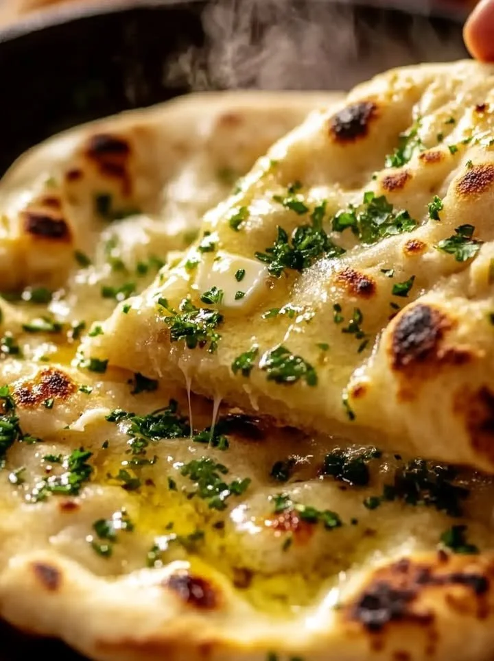 Freshly baked artisan garlic naan with herbs and spices