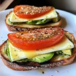 Avocado mozzarella and tomato grilled cheese sandwich served on a plate
