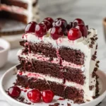 Delicious slice of Black Forest Cake topped with cherries and whipped cream.