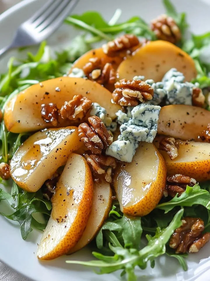Caramelized pear and blue cheese salad topped with walnuts and greens