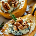 Caramelized pears topped with blue cheese and walnuts on a plate