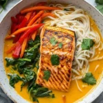 Delicious Coconut Curry Salmon served with rice noodles in a vibrant coconut sauce.