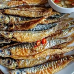 Crispy fried dried fish served on a plate with garnishes