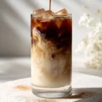 Dirty horchata latte with espresso swirl in a decorative glass.