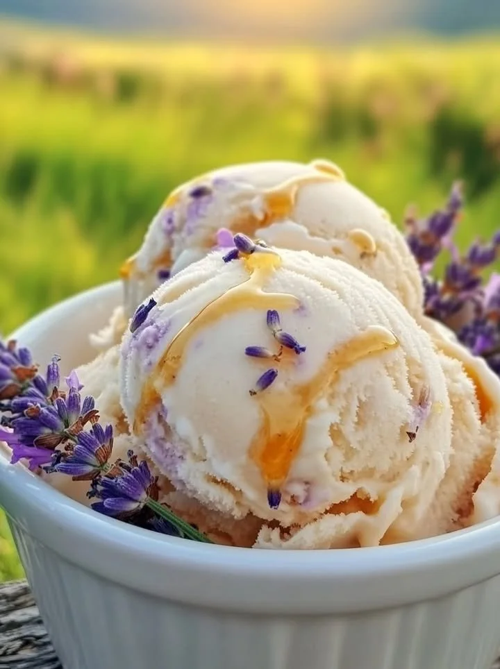 Delicious honey lavender ice cream in a bowl, garnished with lavender flowers.