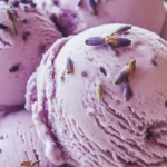 Creamy honey lavender ice cream in a bowl with lavender sprigs