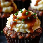 Meatloaf cupcakes topped with whipped potato frosting, beautifully plated.