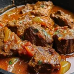 Nigerian beef stew served in a bowl with fresh herbs and spices.
