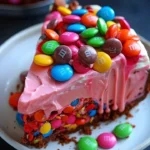 Pink Paradise No-Bake Cheesecake topped with M&M candies and toffee pieces