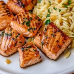 Savory salmon bites beautifully plated with lemon butter orzo.