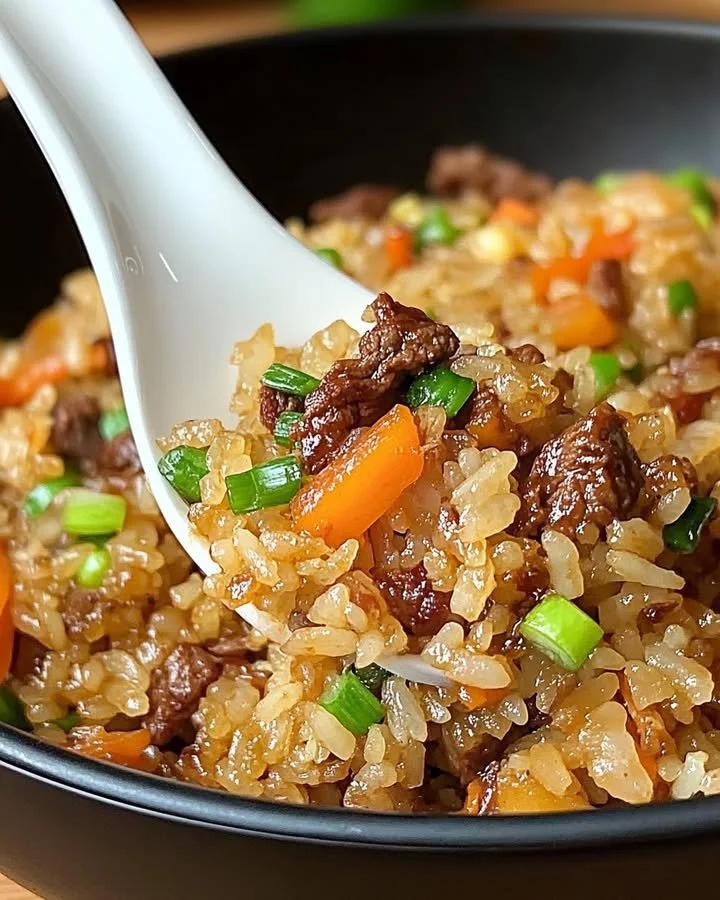 Plate of savory onion beef fried rice with fresh vegetables